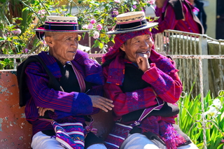 Two older Sanjuaneros sit and chat on a bench in the central plaza of San Juan Atitán.